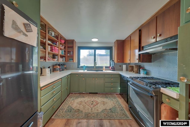 kitchen featuring sink, decorative backsplash, light wood-type flooring, and appliances with stainless steel finishes