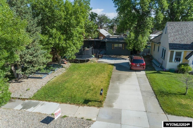 view of front of house with a front lawn and a trampoline