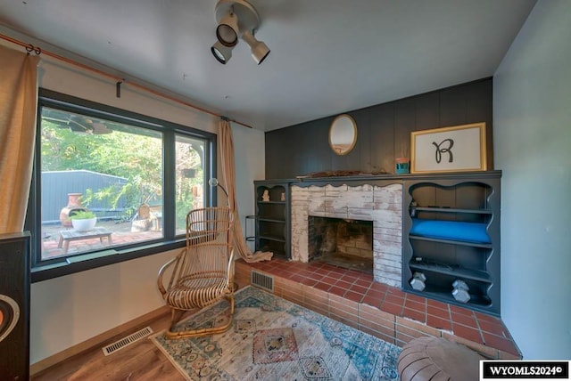 living room featuring hardwood / wood-style floors and a brick fireplace