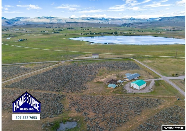 birds eye view of property featuring a water and mountain view and a rural view