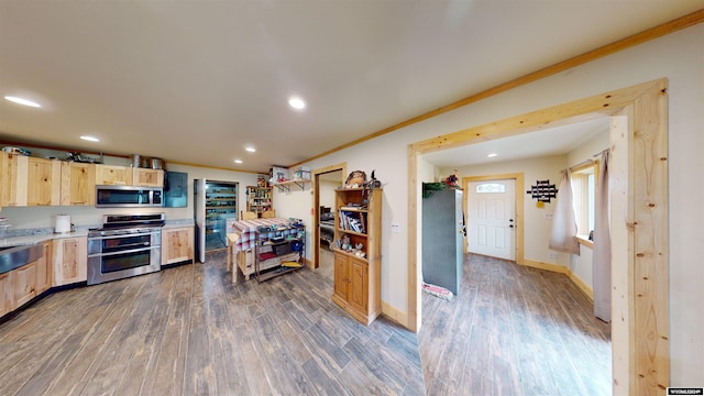 kitchen featuring light brown cabinets, dark hardwood / wood-style floors, stainless steel appliances, and ornamental molding