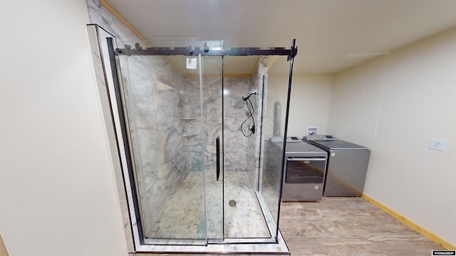 bathroom featuring a shower with door and washer and dryer