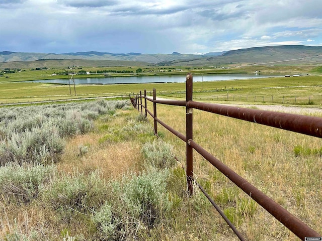 exterior space featuring a water and mountain view and a rural view