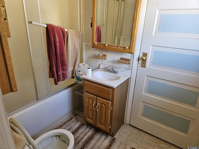 bathroom featuring tile patterned floors, decorative backsplash, vanity, and bath / shower combo with glass door