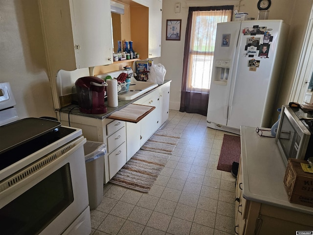 kitchen with white cabinets, white appliances, and sink