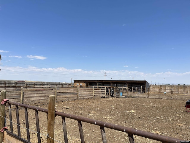 view of yard with a rural view, an outdoor structure, and an exterior structure