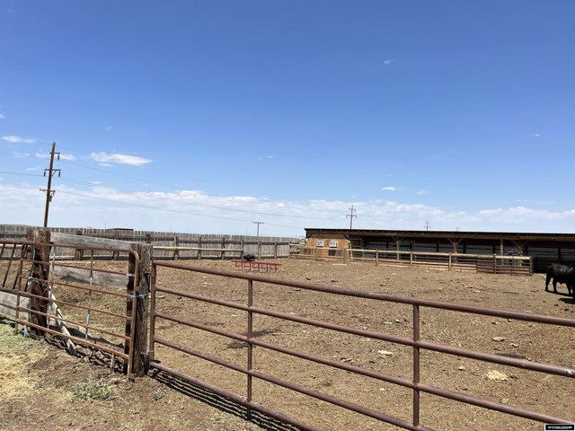 view of yard with a rural view, an outdoor structure, and an exterior structure