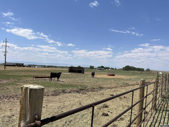 view of yard featuring a rural view and fence