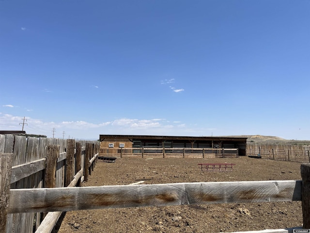 view of yard featuring an outbuilding, an exterior structure, and a rural view