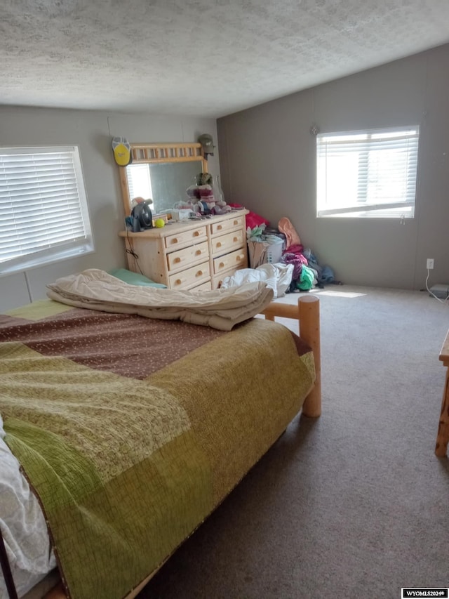 carpeted bedroom with vaulted ceiling and a textured ceiling