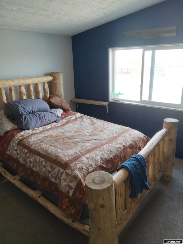 carpeted bedroom with lofted ceiling and a textured ceiling