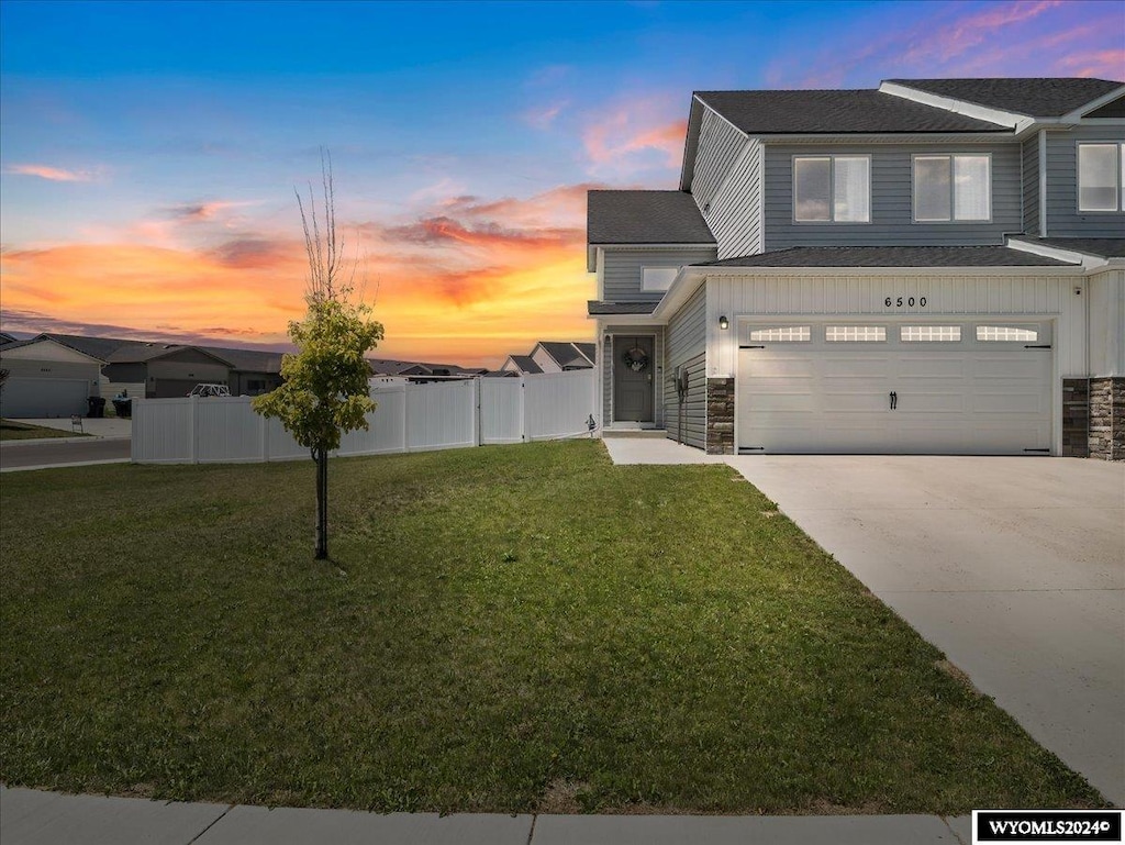 view of front facade with a garage and a yard