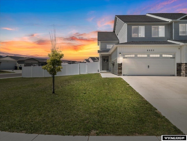 view of front facade with a garage and a yard