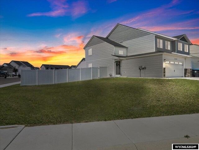 property exterior at dusk with a garage and a yard