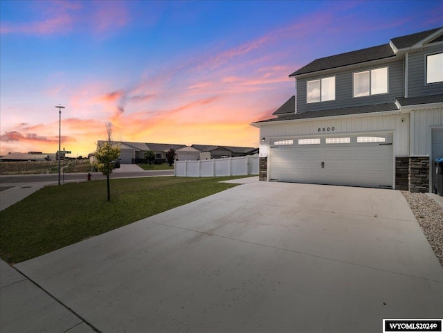 property exterior at dusk featuring a garage and a yard