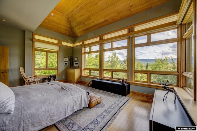 bedroom with multiple windows, high vaulted ceiling, wooden ceiling, and light wood-type flooring