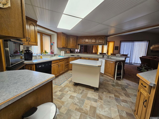 kitchen featuring a breakfast bar, dishwasher, a kitchen island, tile patterned floors, and black dishwasher