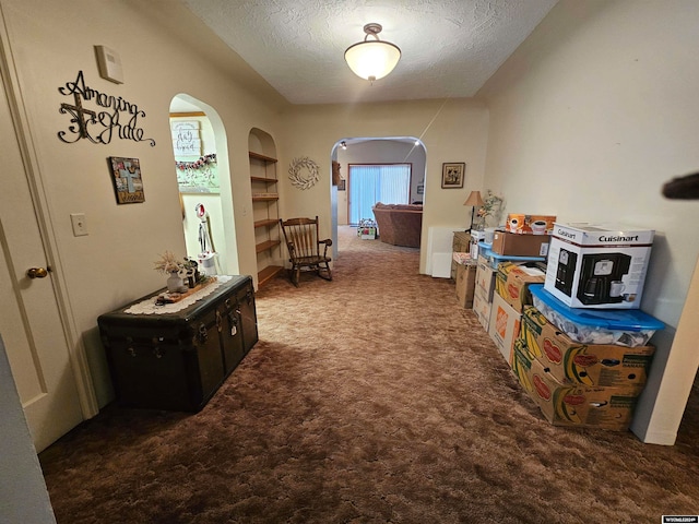 hallway featuring carpet and a textured ceiling