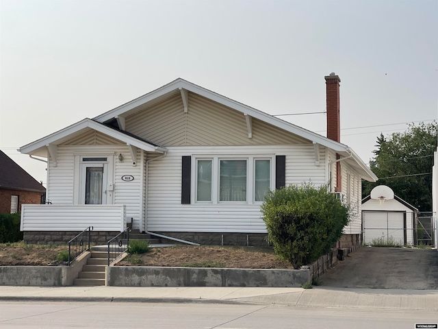 view of front of property with a garage and an outbuilding