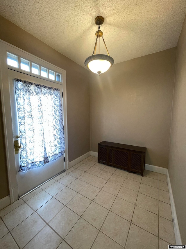 foyer entrance featuring light tile patterned floors and a textured ceiling