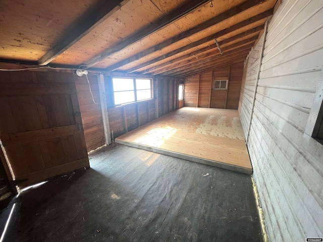 interior space with wood walls, hardwood / wood-style flooring, and vaulted ceiling