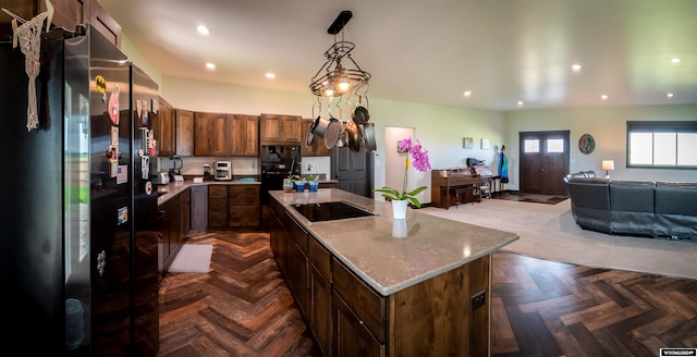 kitchen with recessed lighting, black appliances, pendant lighting, open floor plan, and a center island