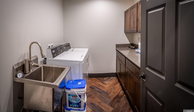 laundry area with washing machine and dryer, cabinet space, baseboards, and a sink