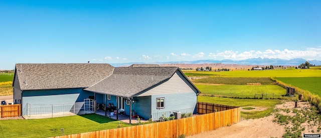 view of front facade featuring a patio area, a rural view, a mountain view, and a fenced backyard