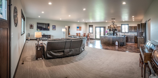 living room with recessed lighting, visible vents, baseboards, and an inviting chandelier