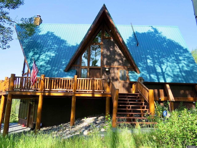 rear view of property featuring a wooden deck