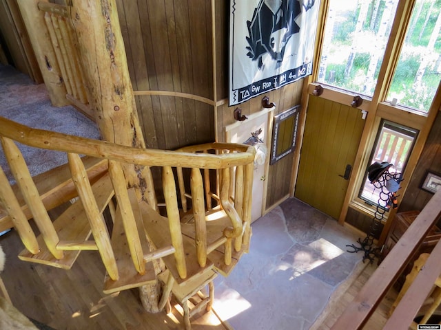 foyer entrance featuring wooden walls and a wealth of natural light