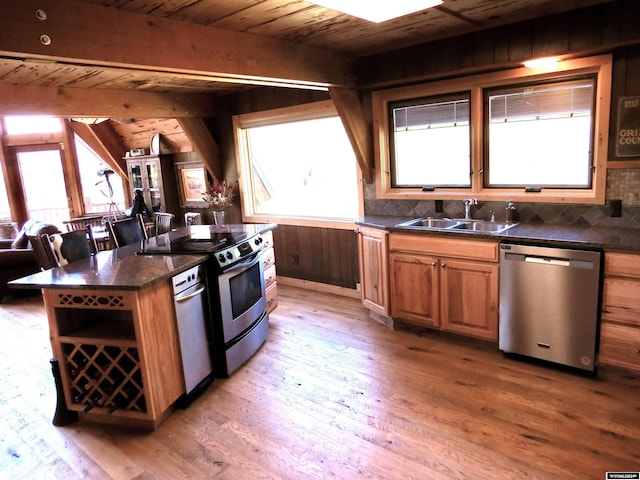 kitchen with range, a center island, stainless steel dishwasher, hardwood / wood-style flooring, and sink