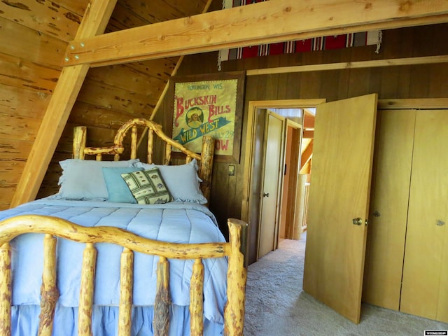 bedroom featuring wood walls, carpet flooring, and a closet