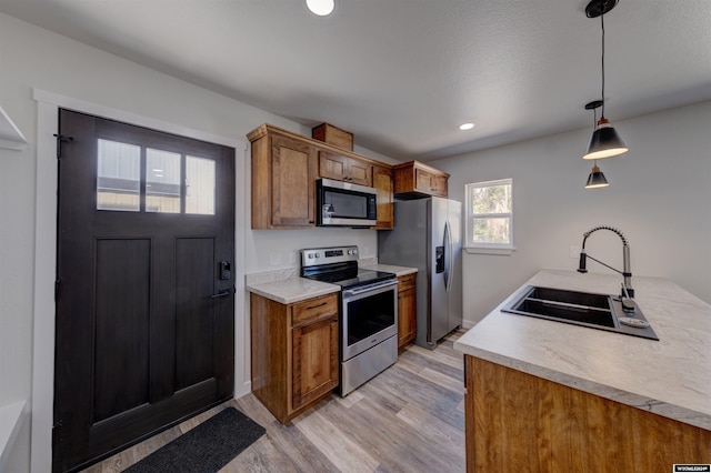 744 E Loucks St, Sheridan, WY 82801 - kitchen with sink, light hardwood / wood-style floors, hanging light fixtures, and stainless steel appliances