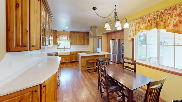 kitchen with a center island, sink, ventilation hood, stainless steel refrigerator, and black electric cooktop