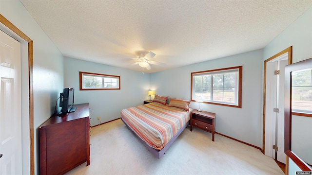 bedroom with multiple windows, light colored carpet, and ceiling fan