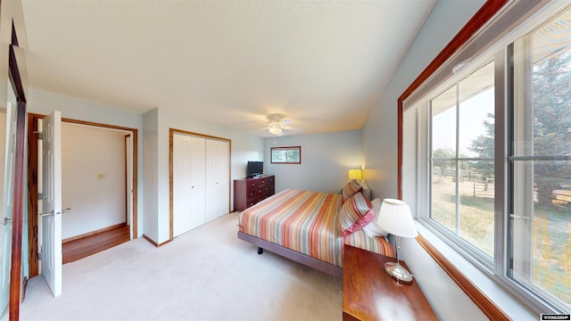 bedroom with a closet, ceiling fan, and light carpet