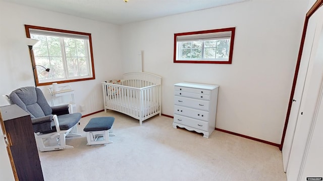 bedroom with light carpet and a crib