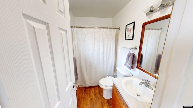 bathroom with hardwood / wood-style floors, toilet, and vanity