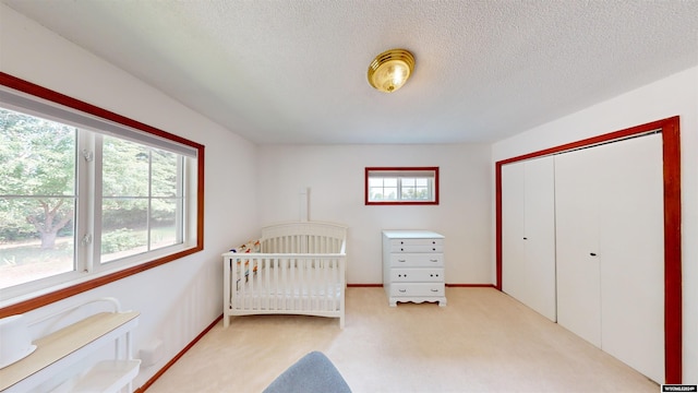 carpeted bedroom with a textured ceiling and a closet