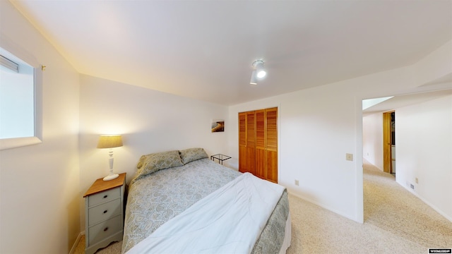 bedroom with light carpet and a closet