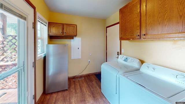 washroom with cabinets, electric panel, washing machine and dryer, and dark hardwood / wood-style flooring