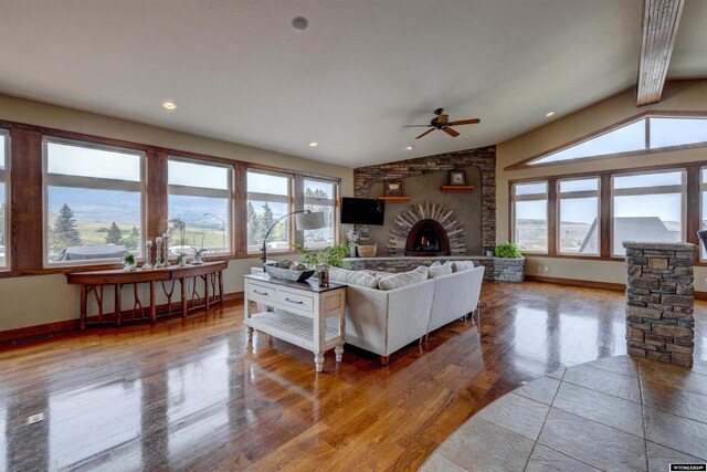 living room with baseboards, wood finished floors, vaulted ceiling, a fireplace, and recessed lighting