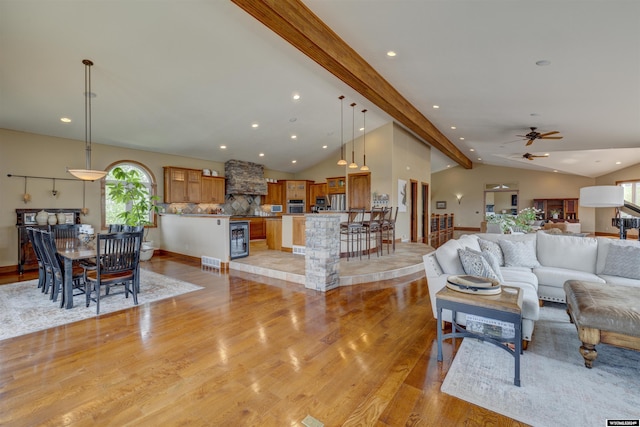 living room with lofted ceiling with beams, recessed lighting, beverage cooler, visible vents, and light wood-type flooring