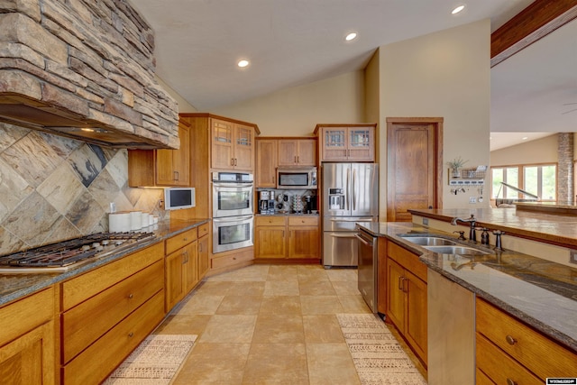 kitchen featuring glass insert cabinets, brown cabinets, a sink, and appliances with stainless steel finishes