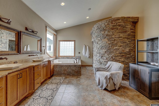 full bath featuring a bath, double vanity, vaulted ceiling, and a sink