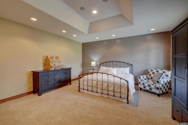 bedroom with recessed lighting, a tray ceiling, light carpet, and baseboards