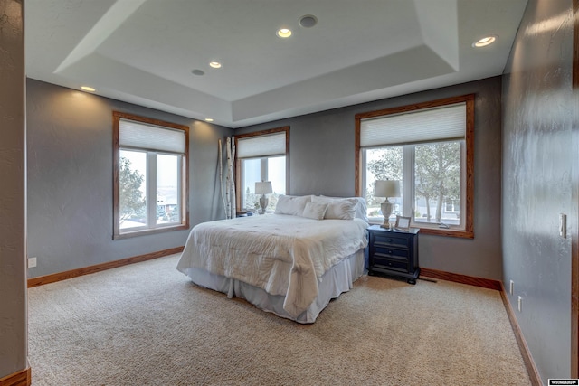 bedroom with recessed lighting, a raised ceiling, light colored carpet, and baseboards