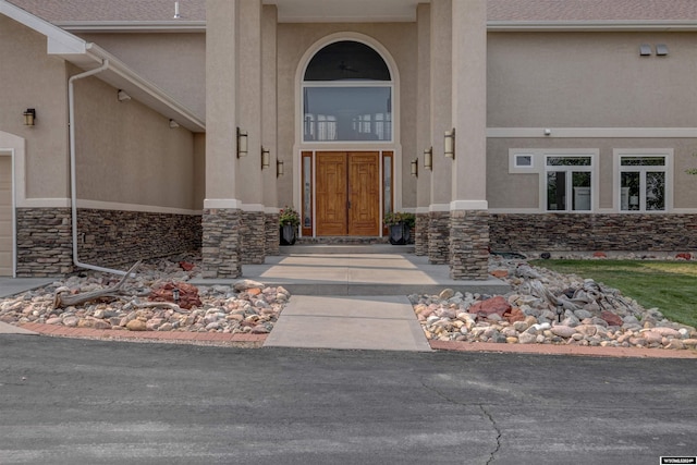 property entrance featuring stone siding and stucco siding