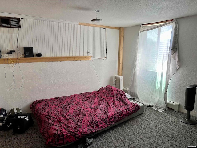 bedroom with radiator, carpet, a baseboard radiator, and a textured ceiling